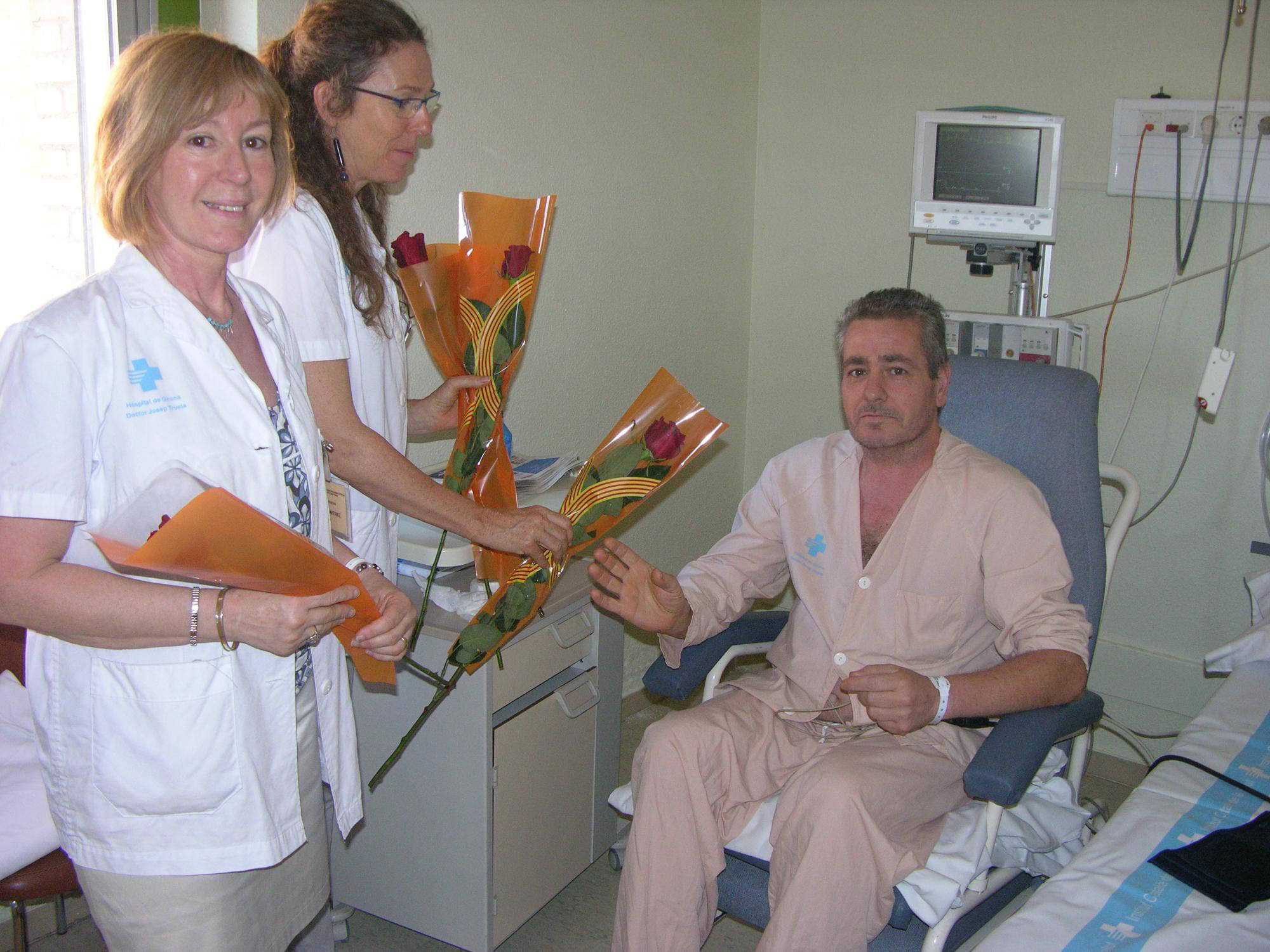 Personal de l'hospital donant una rosa per Sant Jordi a un pacient
